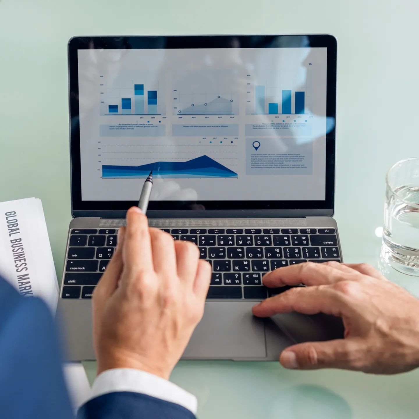 Mãos em um notebook com painel de resultados de vendas