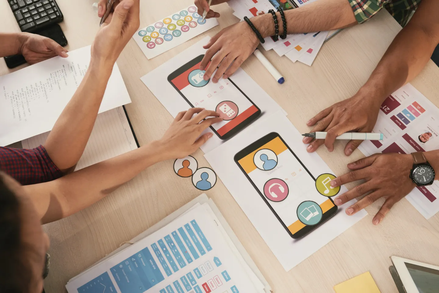 Equipe planejando conteúdo para redes sociais com celulares e materiais sobre a mesa